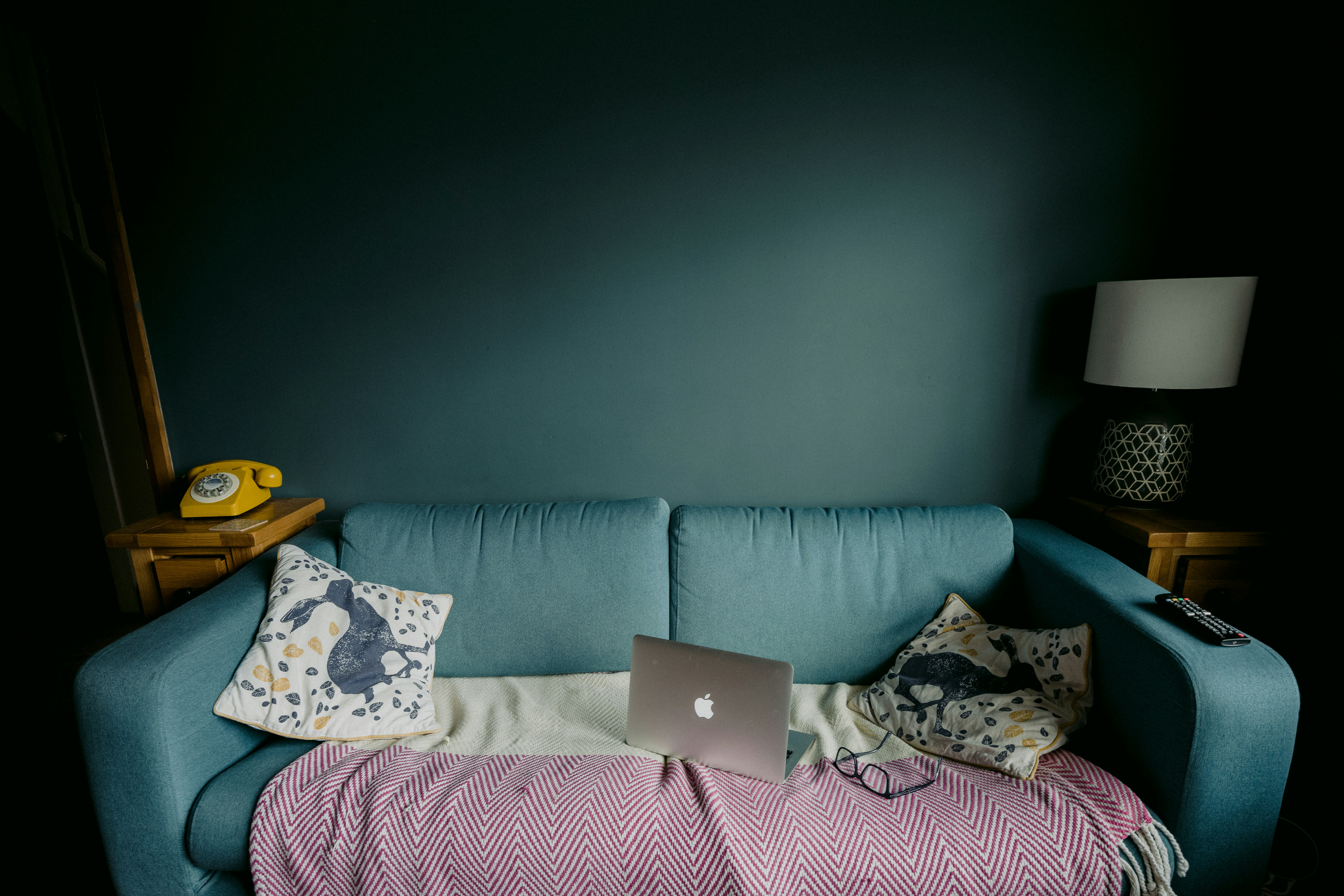 silver macbook on white and pink floral pillow